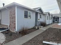 Brick and gray siding duplex with walkway and landscaping at 2027 Terry St # 1, Longmont, CO 80501