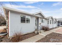 Charming single-story home featuring gray siding and a well-maintained front yard at 2027 Terry St # 1, Longmont, CO 80501