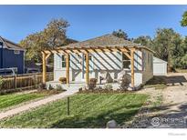 Charming bungalow with pergola-covered porch and landscaped yard at 241 Gay St, Longmont, CO 80501