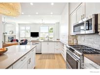 Modern kitchen with white cabinets, stainless steel appliances, and quartz countertops at 3301 Arapahoe Ave # 117, Boulder, CO 80303