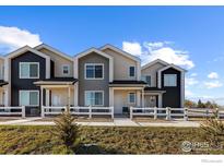 Modern townhome exterior with gray and white paint, landscaping, and a walkway at 500 S Denver Ave # 2B, Fort Lupton, CO 80621