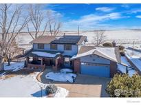 Aerial view of a ranch style home with a large yard and solar panels at 5580 Colt Dr, Longmont, CO 80503