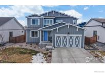 Two-story home with gray siding and blue door at 605 Wild Honey Dr, Berthoud, CO 80513