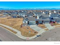 Stunning aerial view of a suburban home with mountain views, showcasing the neighborhood and surrounding landscape at 6325 Copper Dr, Erie, CO 80516