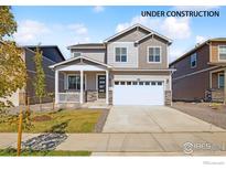 Two-story house with gray siding, white garage door, and landscaping at 6530 13Th St, Frederick, CO 80530