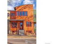 Unique multi-colored townhome facade with arched roofline and bold red window trim at 820 Tenacity Dr, Longmont, CO 80504