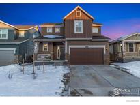 Two-story house with brown siding, attached garage, and snowy front yard at 850 Mosquito Ct, Elizabeth, CO 80107