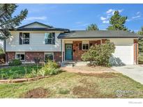 Charming two-story home with brick and painted siding, inviting curb appeal, attached garage, and a blue front door at 1055 Jade St, Broomfield, CO 80020