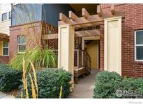 Attractive brick building with yellow and blue accents, featuring a landscaped lawn and walkway at 11310 Colony Cir, Broomfield, CO 80021