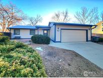 Ranch-style home with attached garage and mature landscaping at 1248 Ilium Dr, Lafayette, CO 80026