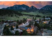 Aerial view of house and neighborhood with mountain views at sunset at 1715 View Point Rd, Boulder, CO 80305