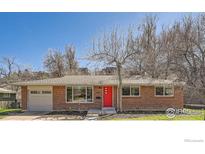 Brick ranch home with red door, attached garage, and landscaped yard at 2000 Edgewood Dr, Boulder, CO 80304