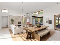 Bright, open-concept living room with a stone fireplace, modern lighting, and large windows at 2125 Upland Ave, Boulder, CO 80304