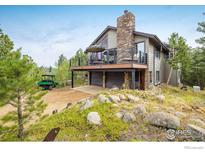 Stunning mountain home with stone chimney, deck, and garage at 302 Deer Trail Cir, Boulder, CO 80302