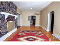 Cozy dining room features hardwood floors, a stone fireplace, and a southwestern rug at 350 Florence Ave, Firestone, CO 80520