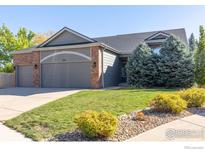 Well-maintained front yard featuring a lush lawn, mature trees, and beautiful landscaping at 440 Andrew Way, Superior, CO 80027