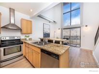 Well-lit kitchen featuring stainless steel appliances, granite countertops, and an open layout to the dining area and outdoor patio at 4645 Broadway St # C-1, Boulder, CO 80304