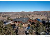 Aerial view of a luxurious ranch home with mountain views and solar panels at 515 Indian Mountain Rd, Longmont, CO 80503