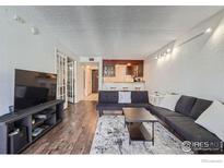 Bright living room with hardwood floors, comfy seating, and a view into the kitchen at 805 29Th St # 405, Boulder, CO 80303