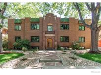 Charming brick apartment building with beautiful landscaping and green trim at 1342 Milwaukee St # 5, Denver, CO 80206