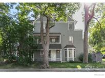 Gray two-story house with a porch and mature trees in the front yard at 1430 18Th St # 1, Boulder, CO 80302