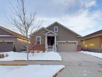 Charming single-story home featuring a two-car garage, brick accents, and a cozy front porch, perfect for suburban living at 1465 Otis Dr, Longmont, CO 80504