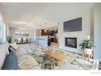 Open living room features a fireplace and kitchen with island at 2417 Calais Dr # G, Longmont, CO 80504