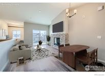 Virtually staged living room with fireplace and sliding glass door to balcony at 2435 Calais Dr # I, Longmont, CO 80504