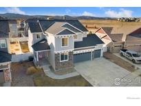 Aerial view of a home with a three-car garage, complemented by mountain views at 2483 Tabor St, Berthoud, CO 80513