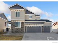 Attractive two-story house with a three-car garage and manicured lawn on a sunny day at 2483 Tabor St, Berthoud, CO 80513