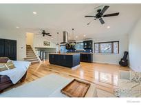 Spacious open-concept living room with hardwood floors and a modern kitchen island at 4667 Harwich St, Boulder, CO 80301