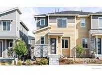 Two-story townhome with neutral siding and stone accents at 5335 Spalding Pl, Frederick, CO 80504