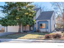 Charming two-story home features a well-manicured lawn and a beautiful tree in the front yard at 538 W Spruce Way, Louisville, CO 80027