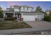 Two-story house with gray siding, brick accents, and a two-car garage at 615 Allen Dr, Longmont, CO 80503