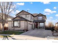 Charming two-story home with brick accents, a front porch, and an attached two-car garage at 6433 Eagle Butte Ave, Frederick, CO 80516