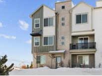 Stylish townhome showcases brick and siding, complemented by black awning and front door at 12111 W 57Th Dr, Arvada, CO 80002