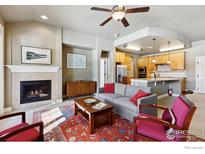 Inviting living room featuring a cozy fireplace, neutral color palette and seamlessly connected to the kitchen at 1379 Charles Dr # 6, Longmont, CO 80503