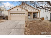 Charming single-story home featuring a well-manicured lawn and attached two-car garage at 1439 Wildrose Dr, Longmont, CO 80503