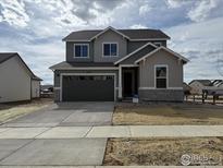 Charming two-story home with a well-manicured lawn, complemented by an attached two-car garage at 16835 Mckay Dr, Mead, CO 80542