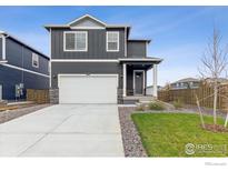 Charming two-story home with gray siding, a two-car garage, and a well-maintained front yard at 1813 Pinnacle Ave, Lochbuie, CO 80603