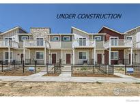Modern townhomes featuring balconies and well-maintained landscaping, currently under construction at 2752 Bear Springs Cir, Longmont, CO 80503