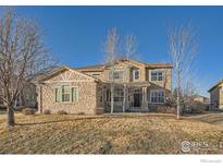 Beautiful two-story home featuring stone accents, landscaped front yard, and inviting front porch at 2879 Hilltop Ct, Broomfield, CO 80023