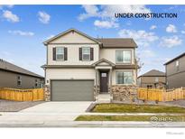 New two-story home featuring stone accents, neutral siding, two car garage, and a well-manicured lawn at 837 Ledge St, Lochbuie, CO 80603