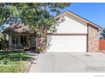 Charming home exterior with a well-maintained lawn, attached garage, and inviting front porch at 104 Plowshare Ln, Platteville, CO 80651