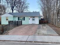 Inviting single-story home with a brick parking area and classic white trim at 144 E 5Th Ave, Longmont, CO 80504