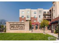 Modern building exterior featuring brick and siding and a manicured lawn with branded sign at 3701 Arapahoe Ave # 318, Boulder, CO 80303