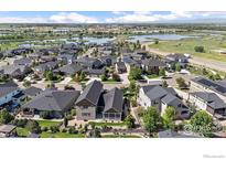 Aerial view of home with nearby lakes and ponds in a residential neighborhood at 4565 Colorado River Dr, Firestone, CO 80504