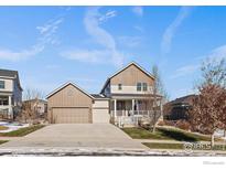 Charming two-story home with a covered front porch and attached two-car garage at 4565 Colorado River Dr, Firestone, CO 80504