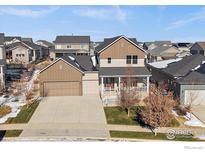 Charming two-story home with a well-manicured lawn and inviting front porch at 4565 Colorado River Dr, Firestone, CO 80504