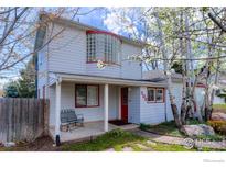 Charming two-story home featuring red trim, a cozy porch, and a unique glass block window detail at 508 Valley View Dr, Boulder, CO 80304